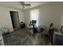 Bedroom with gray wood-look floors, white walls, and ceiling fan at 731 Trenton Rd, Lakeland, FL 33815