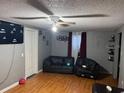 Comfortable living room with dark couches and ceiling fan at 10538 Clarcona Ocoee Rd, Apopka, FL 32703