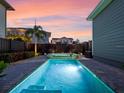 A tranquil backyard pool area with a sun deck is framed by lush tropical landscaping at 13041 Gabor Ave, Orlando, FL 32827