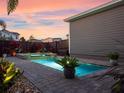 Inviting pool and jacuzzi with brick pavers, mature landscaping and privacy fence at sunset at 13041 Gabor Ave, Orlando, FL 32827