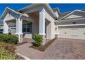 Close up of charming two-story home with well-manicured landscaping and brick-paved walkway at 14321 Wabasso Loop, Winter Garden, FL 34787