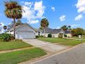 View of a street featuring homes with well-manicured lawns and driveways on a sunny day at 1718 Golfview Dr, Kissimmee, FL 34746