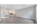 Spacious living room with gray tile floors leading to a modern kitchen at 1783 Coriander Dr, Kissimmee, FL 34759