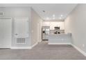 Open-concept living room showcases modern finishes, connecting to a kitchen with stainless steel appliances at 1785 Coriander Dr, Kissimmee, FL 34759