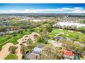 Aerial view of community with golf course, lush landscaping, nearby shopping, and recreation at 2105 Mallory Cir, Haines City, FL 33844