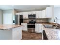 Modern kitchen with stainless steel appliances, granite countertops, and white cabinetry at 214 Kay St, Auburndale, FL 33823