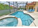 Inviting screened-in pool area with a heated pool and spa, perfect for relaxation and entertaining at 215 Cordova Ave, Davenport, FL 33897