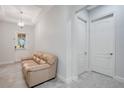 Bright foyer boasts neutral tones, tiled floors, and a cozy sofa at 2460 Promenade Dr, St Cloud, FL 34772