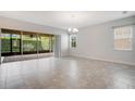Open concept living area featuring tile flooring, large windows, and access to the screened patio at 2460 Promenade Dr, St Cloud, FL 34772