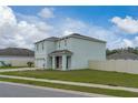 Two-story home with a well-maintained lawn, featuring a charming covered entryway and attached garage at 3188 Serendipity Way, Davenport, FL 33896