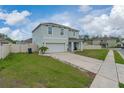 A beautifully landscaped lawn surrounds this two-story house with an attached two-car garage at 3188 Serendipity Way, Davenport, FL 33896