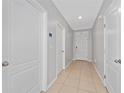 Inviting hallway with tile flooring, neutral walls, and white doors leading to various rooms at 3188 Serendipity Way, Davenport, FL 33896