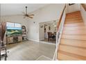 Bright living room featuring vaulted ceilings, wood-look floors, and a staircase leading to the upper level at 3203 Rio Grande Trl, Kissimmee, FL 34741