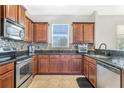 Beautiful kitchen featuring stainless steel appliances, granite countertops, and warm wooden cabinetry at 3471 Julius Estates Blvd, Winter Haven, FL 33881