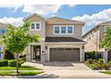 Charming two-story home featuring a stone-accented facade, paver driveway, and a well-maintained lawn at 385 Southfield St, Kissimmee, FL 34747
