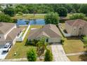 Home on a well-manicured lot with a view of a tranquil pond and neighboring houses at 502 Woodland Creek Blvd, Kissimmee, FL 34744