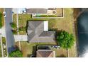 Home with brown roof, and expansive backyard along the lake in quiet residential neighborhood at 502 Woodland Creek Blvd, Kissimmee, FL 34744