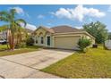 A well-maintained home with a two-car garage, complemented by a neatly landscaped lawn at 502 Woodland Creek Blvd, Kissimmee, FL 34744