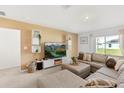 Cozy living room featuring a plush sectional sofa, modern entertainment center, and bright natural light from the window at 541 Jerry Ln, Haines City, FL 33844