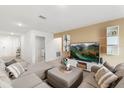 Comfortable living room showcasing a large sectional sofa, modern entertainment center, and stylish decor at 541 Jerry Ln, Haines City, FL 33844