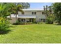 Charming two-story home with a metal roof, surrounded by lush landscaping, and a green lawn at 6100 Alligator Lake W Shr, St Cloud, FL 34771