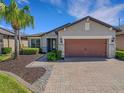 Beautiful single-story home with a brick driveway, stone accents, and a two-car garage at 688 Cordoba Dr, Davenport, FL 33837