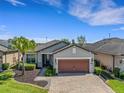 Well-maintained home with a brick driveway, lush landscaping, and a two-car garage at 688 Cordoba Dr, Davenport, FL 33837