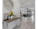 Bright hallway that leads to the living area with marble floors, offering an open and airy feel throughout the home at 978 Splash Shot Pl, Davenport, FL 33896