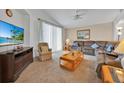 Inviting living room with plush carpet, comfortable seating, and a large TV for entertainment at 1010 Prey Ct, Kissimmee, FL 34746