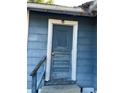 Weathered blue front door framed by white trim, showcasing the entry to this fixer-upper's potential at 1011 26Th Street, Orlando, FL 32805