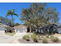 Inviting single-Gathering home boasts mature landscaping, including a palm tree, and an attached two-car garage at 1017 Winding Water Way, Clermont, FL 34714