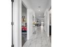 Inviting hallway with marble tile, views of the living room and Disney-themed bedroom providing a glimpse of Gathering life at 1034 Splash Shot Pl, Davenport, FL 33896