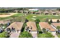 Aerial view of the property featuring a golf course view, mature trees, and well-manicured landscaping at 1335 Palmetto Dunes St, Davenport, FL 33836