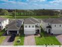 An elevated view of a traditional suburban home with brick drive, green lawn, and neighboring houses at 1371 Red Blossom Ln, Kissimmee, FL 34746