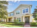Charming two-story home with well-manicured lawn and a welcoming front porch at 15687 Kinnow Mandarin Ln, Winter Garden, FL 34787