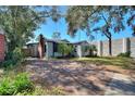 Wide brick driveway leading to a cozy home surrounded by mature landscaping and trees at 204 E Harvard St, Orlando, FL 32804