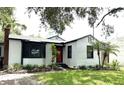 Charming single-story home with a red door, well-maintained lawn, and complemented by lush landscaping at 204 E Harvard St, Orlando, FL 32804