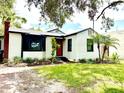 Charming single-story home featuring a red door, bay window, fresh landscaping, and a brick chimney at 204 E Harvard St, Orlando, FL 32804
