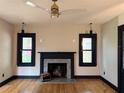 Cozy living room highlights a fireplace, hardwood floors, and natural light from the windows at 204 E Harvard St, Orlando, FL 32804