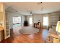 Spacious living room featuring laminate flooring, a ceiling fan, and large windows that let in natural light at 222 Palmer Park Ln, Davenport, FL 33897