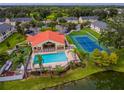 Aerial view of the neighborhood clubhouse featuring pool, tennis court, and lush landscaping at 2794 Club Cortile Cir # B, Kissimmee, FL 34746