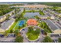 Aerial community view showcases a central lake, manicured landscaping, tennis courts, and a clubhouse at 2794 Club Cortile Cir # B, Kissimmee, FL 34746