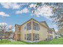 Rear exterior view showing a private screened-in patio and second-story balcony with convenient stair access at 2794 Club Cortile Cir # B, Kissimmee, FL 34746