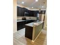 Modern kitchen features dark wood cabinets, granite countertops, stainless steel appliances, and a stylish island at 2802 Glendive Dr, Kissimmee, FL 34758