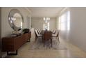 Elegant dining room with a wood sideboard, round mirror, and stylish table setting, illuminated by modern chandelier at 3607 Hidden River Ln, Tavares, FL 32778