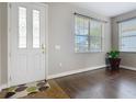 Inviting foyer with decorative front door, tile and hardwood flooring, and ample natural light from nearby windows at 3709 Cedar Hammock Trl, St Cloud, FL 34772