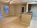 Living room features neutral paint, ceiling fan, tile flooring and a window at 401 Fountainhead Cir # 155, Kissimmee, FL 34741