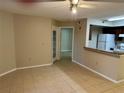 Living room features neutral paint, ceiling fan, tile flooring and pass through to kitchen at 401 Fountainhead Cir # 155, Kissimmee, FL 34741