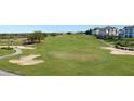 Beautifully manicured golf course featuring lush green fairways, sand traps, and distant community buildings at 7673 Heritage Crossing Way # 301, Reunion, FL 34747