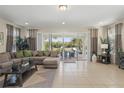 Living room features a comfortable sectional, large windows with patio access, and neutral decor at 785 Desert Mountain Ct, Reunion, FL 34747
